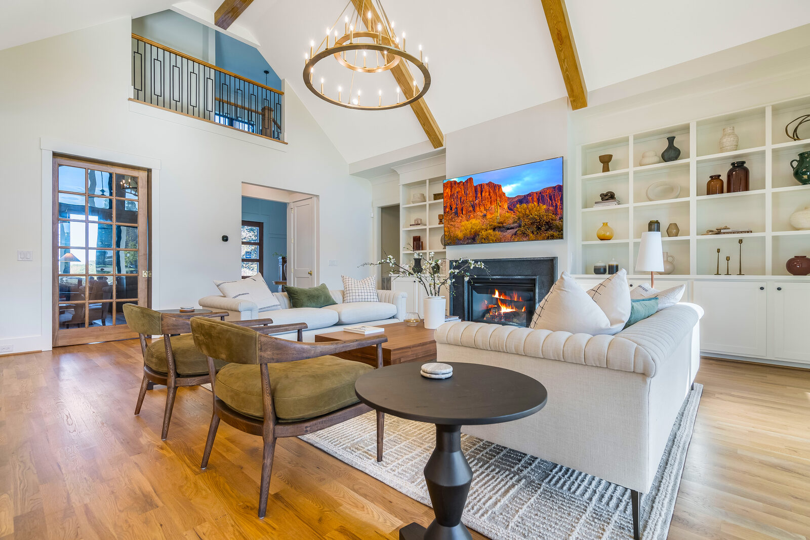 Great room with a lit fireplace in a Gemstone custom home